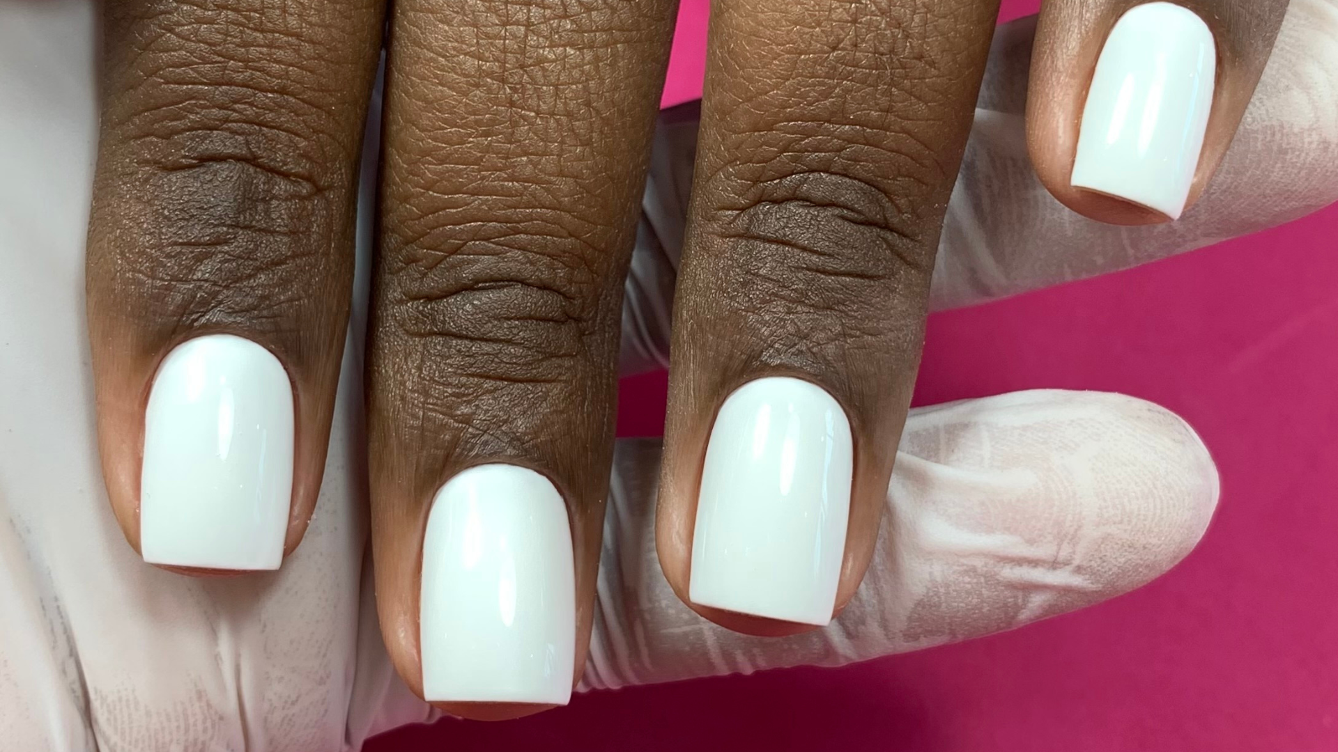 Unhas brancas com acabamento profissional em uma cliente